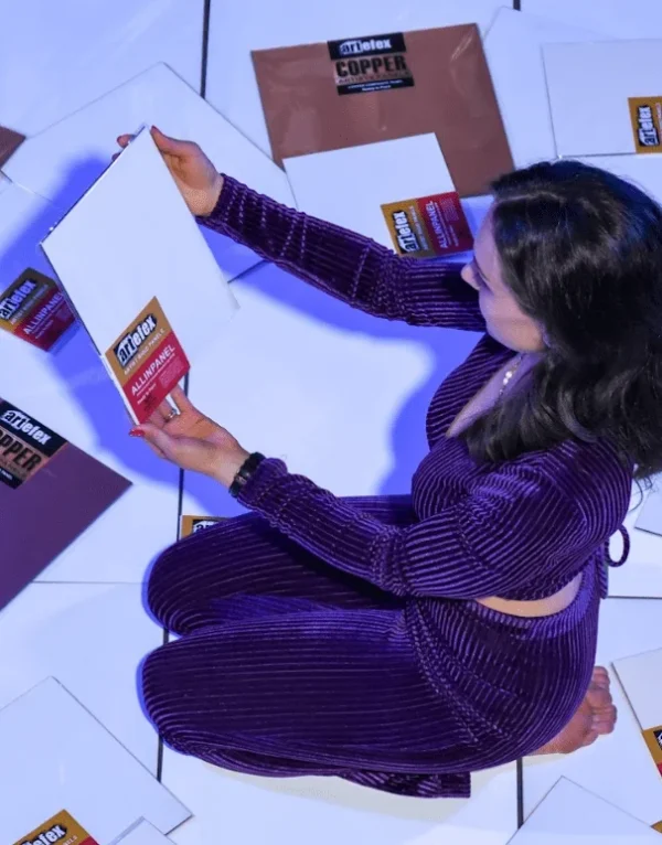 Shelby holding an Artefex panel against a background, showcasing its smooth surface and premium quality for art projects.