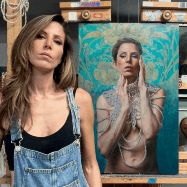 Shana Levenson in denim overalls standing with her ornate self-portrait painting highlighted by turquoise and pearl details.